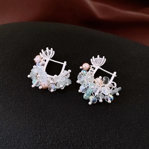 Detail of silver hoop earrings with light blue stones, crystals and pink pearls