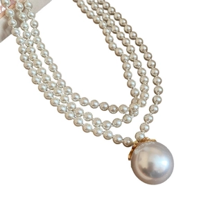Three-layer layered pearl necklace with large pearl pendant and golden accents