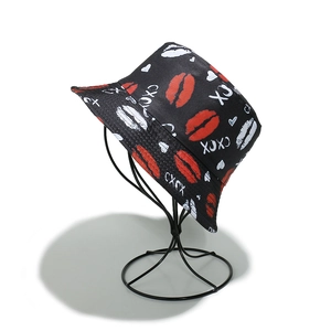 Détail de chapeau bob noir avec imprimés lèvres rouges et lettrage XOXO élégant