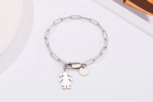 Détail du bracelet chaîne à maillons avec pendentif fille et disque argenté