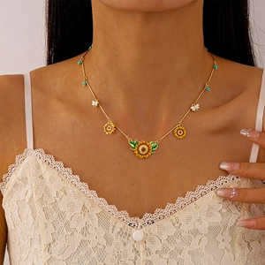 Detail of sunflower and bee necklace with blue beads on a gold chain summer style