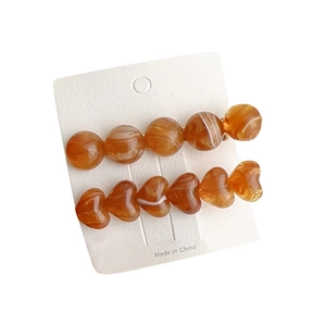 Amber heart and bead hair clips set with marble texture on display card