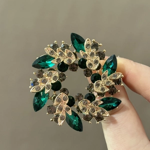Elegant gold wreath brooch with emerald and dark crystal accents for women