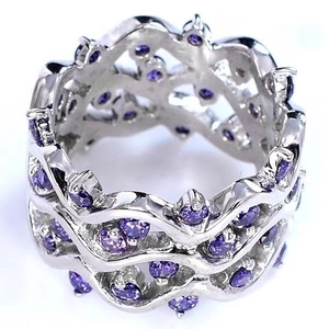 Détail de bagues argentées ondulées avec zircons violets ronds sertis en pavé dense