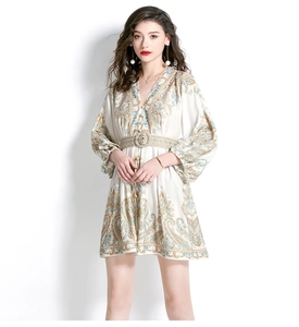 Detail of V-neck printed mini dress with lantern sleeves and paisley pattern on cream fabric