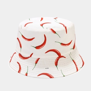 Detailed close-up of white bucket hat featuring a vibrant red chili pepper print pattern