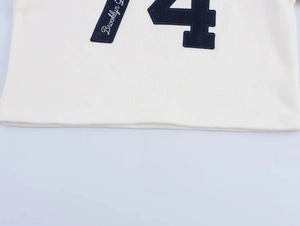 Detail of Brooklyn 4 print and fine knit texture on the white long-sleeved sweatshirt