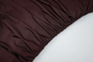 Gros plan sur le tissu élastique froncé bordeaux pour une robe moulante sexy