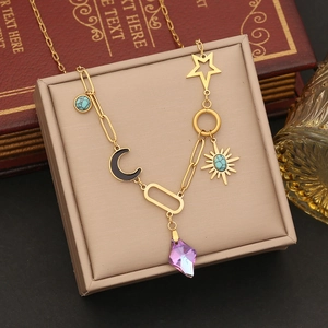 Detailed close-up of gold stainless steel necklace with sun, moon, and star pendants