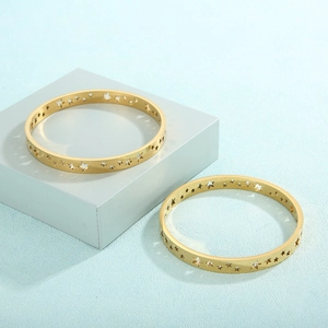 Macro shot of gold hollowed star pattern on polished 18K plated stainless steel bracelet