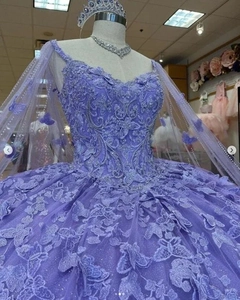 Detail of purple ball gown with intricate lace embroidery and butterfly appliques