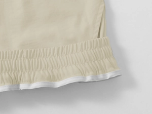 Detail of khaki cargo shorts showing elastic waistband and white piping with fine stitching