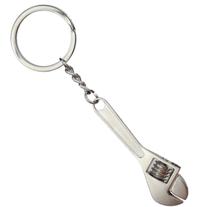 Miniature silver metal wrench keychain with movable gear on a clean white background