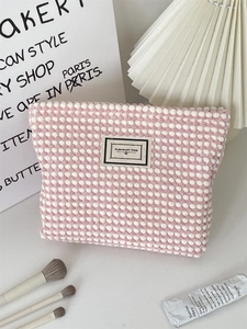 Detailed shot of pink and white waffle dot makeup bag with PLEASANT TIME label