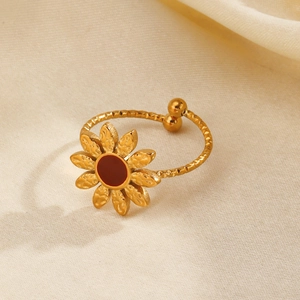 Anello a girasole placcato oro 18K con pietra rossa su sfondo di tessuto testurizzato