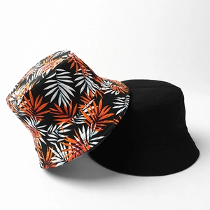 Reversible bucket hat with tropical leaf print and solid black color for sun protection
