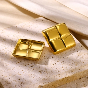 Detailed view of 18K gold plated square earrings with textured geometric surface