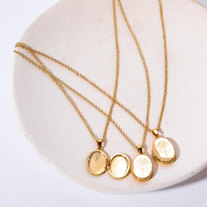 Detail of open and closed oval locket pendants with rose engraving on gold necklaces