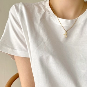 Minimalist 925 sterling silver gold letter pendant necklace worn on a white T-shirt