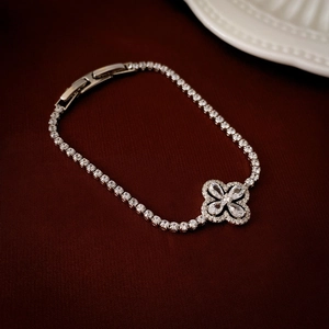 Macro shot of silver clover bracelet with sparkling cubic zirconia on brown velvet
