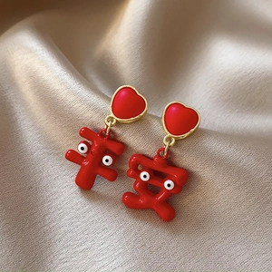 Detail of red heart-shaped earrings with Pingan character on champagne silk