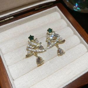 Detailed view of Christmas tree earrings with gold finish, green crystals and pearls