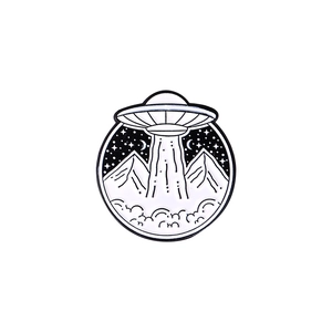 Detailed close-up of a circular enamel pin showing a UFO beaming light over mountains