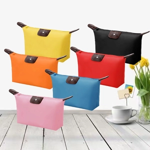 Detailed arrangement of six colorful nylon cosmetic pouches with leather handles on wood