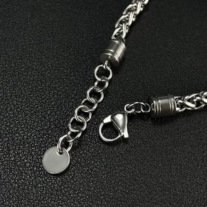 Macro detail of the lobster clasp and braided metal chain with a polished finish