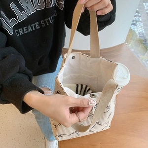 Detail of corduroy tote bag showing magnetic closure and inner pocket in a cafe setting