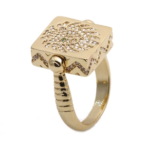 Detailed view of square gold lion head ring with sparkling white and green zircons