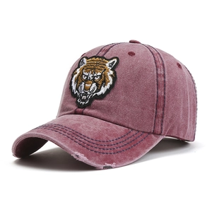 Close-up of vintage washed red cotton baseball cap with tiger head embroidery details