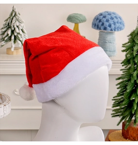 Close-up of red velvet Christmas hat with white plush trim and soft white pom-pom detail