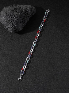 Detail of silver stainless steel chain bracelet with colorful enamel links on black rock