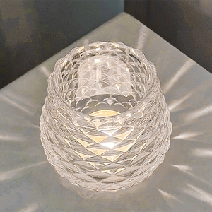 Pinecone textured crystal glass candle holder with glowing candle for romantic dinner