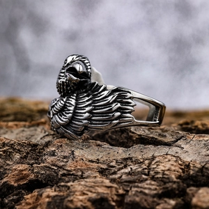Vintage double eagle head stainless steel ring with detailed feather texture on tree bark