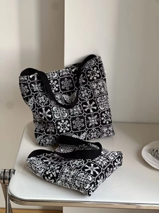 Detail of black canvas tote set featuring intricate white butterfly and floral embroidery