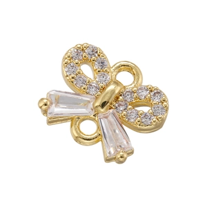 Detailed view of gold bow pendant with micro-pave cubic zirconia and double loops