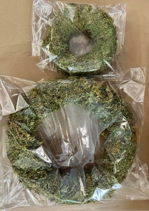 Macro view of natural dried moss wreaths individually wrapped in clear plastic bags