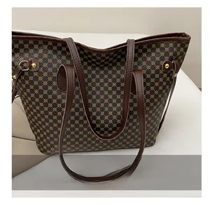 Close-up of comfortable brown leather straps and metal hardware on monogram tote bag