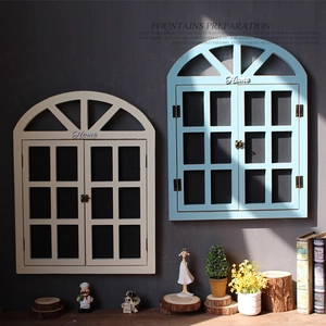 Detail of vintage arch window wall decor in white and blue with rustic metal latches