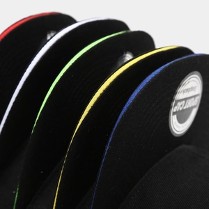 Close-up detail of multi-colored snapback cap brims with contrast sandwich piping