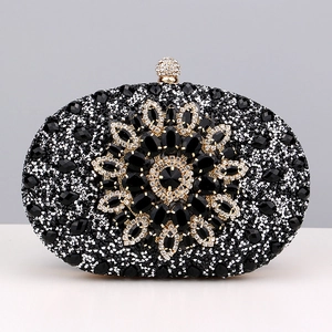 Macro shot of oval evening clutch with black rhinestones and large flower gem pattern