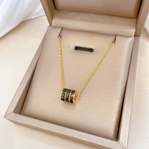 Titanium steel necklace with black cylindrical pendant in a beige velvet jewelry box