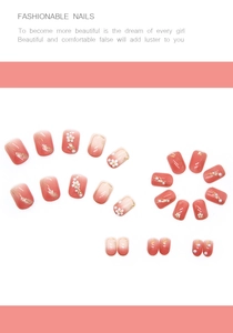 Detail view of pink gradient nails with embossed flowers, gold foil, and pearl accents