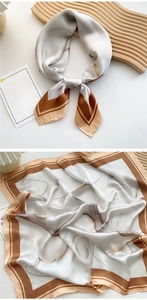 Detailed view of cream silk scarf with geometric brown pattern on a wooden tray