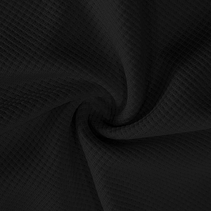 Detailed macro shot of high-quality black waffle knit texture on men's long sleeve henley