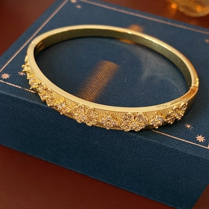 Detailed view of gold plated bangle featuring zircon floral texture and sparkling crystals
