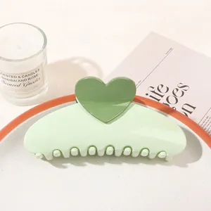 Detail of sweet green heart hair claw clip on a ceramic tray in an elegant home setting