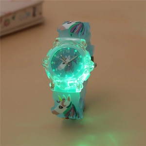 Close-up of kids luminous unicorn watch with glowing green LED display and blue strap